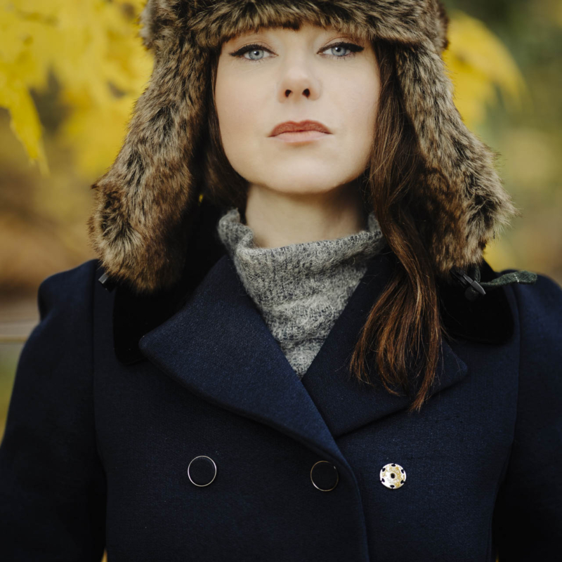 Portret modelki w zimowym płaszczu i czapce-uszatce w jesiennych barwach.