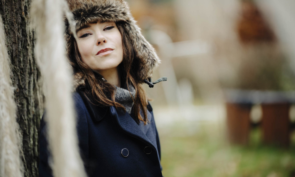 Naturalny portret tajemniczo uśmiechniętej Anny w toruńskim parku, w stylu beauty